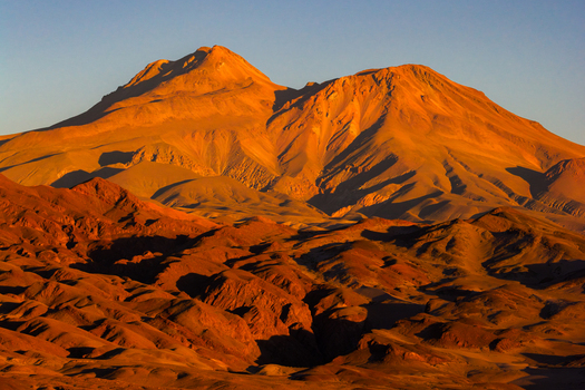 Aerial view of the rugged desert mountains and volcanic peaks glowing in the golden hour light Toconao Antofagasta Chile. Aerial view of the rugged desert mountains and volcanic peaks glowing in the golden hour light Toconao Antofagasta Chile.