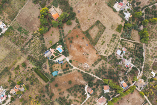 Aerial view of the rural landscape near Riserva Naturale Orientata dello Zingaro with olive groves scattered houses a swimming pool and dirt paths in San Vito Lo Capo Sicilia Italy. Aerial view of the rural landscape near Riserva Naturale Orientata dello Zingaro with olive groves scattered houses a swimming pool and dirt paths in San Vito Lo Capo Sicilia Italy.