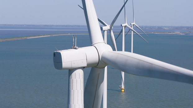 Aerial view of Windpark Fryslan offshore wind turbines standing in the IJsselmeer with large white blades and steel towers in Breezanddijk Friesland Netherlands. Aerial view of Windpark Fryslan offshore wind turbines standing in the IJsselmeer with large white blades and steel towers in Breezanddijk Friesland Netherlands.