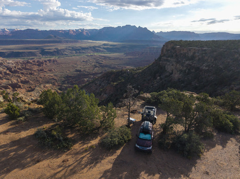 Aerial view of an Overland teardrop camper trailer on Gooseberry Mesa overlooking Zion National Park with desert terrain and rock formations in Hurricane Utah United States.
