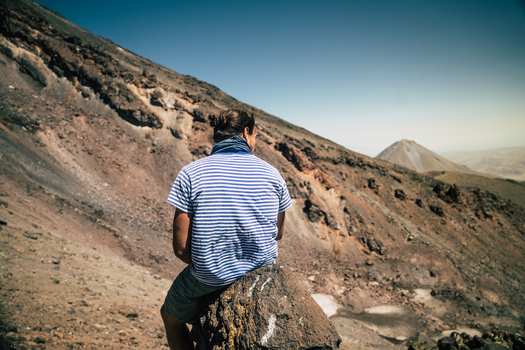 Turkey 15 August 2023 View of a hiker sitting on a volcanic rock slope with Mount Ararat in the background under a clear blue sky. Turkey 15 August 2023 View of a hiker sitting on a volcanic rock slope with Mount Ararat in the background under a clear blue sky.