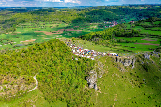 Aerial view of the Walberla hill with crowds gathered for a festival amidst lush green forests and rolling hills in Kirchehrenbach Bavaria Germany. Aerial view of the Walberla hill with crowds gathered for a festival amidst lush green forests and rolling hills in Kirchehrenbach Bavaria Germany.