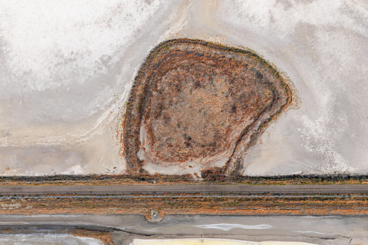 Aerial view of the drying Great Salt Lake showing exposed salt flats and arid terrain near the railroad tracks in Ogden Utah United States. Aerial view of the drying Great Salt Lake showing exposed salt flats and arid terrain near the railroad tracks in Ogden Utah United States.
