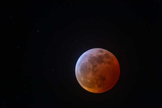 View of the moon during a lunar eclipse against the dark night sky in Canada. View of the moon during a lunar eclipse against the dark night sky in Canada.