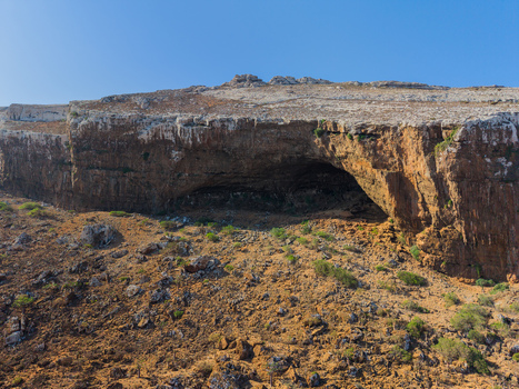 Aerial view of the rugged landscape and entrance to Hoq Cave under a clear sky Erissel Socotra Yemen.