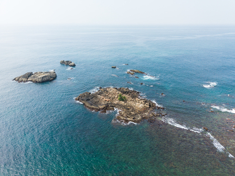 Aerial view of small rocky islets surrounded by turquoise ocean water and gentle waves Galle Southern Province Sri Lanka. Aerial view of small rocky islets surrounded by turquoise ocean water and gentle waves Galle Southern Province Sri Lanka.