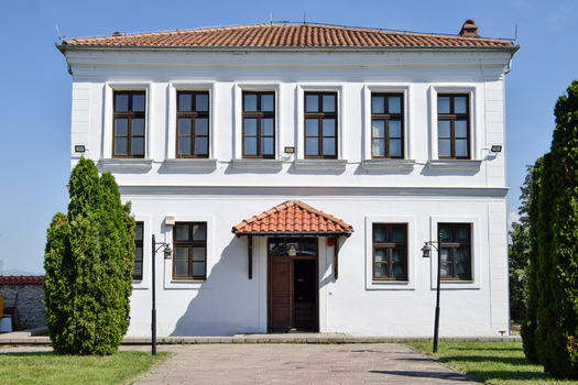 View of the historic Emin Gjiku Ethnological Museum with its white facade tiled roof and symmetrical windows in Pristina Kosovo.