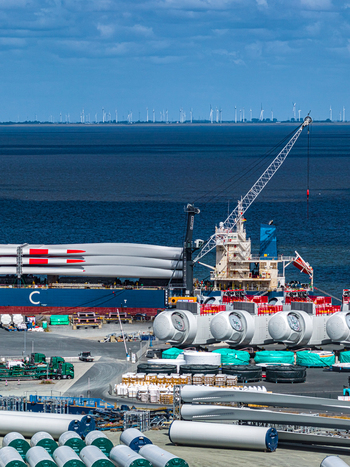 Aerial view of wind turbine blades and components at the Siemens Gamesa Renewable Energy facility in the port with a cargo ship docked in Cuxhaven Niedersachsen Germany.