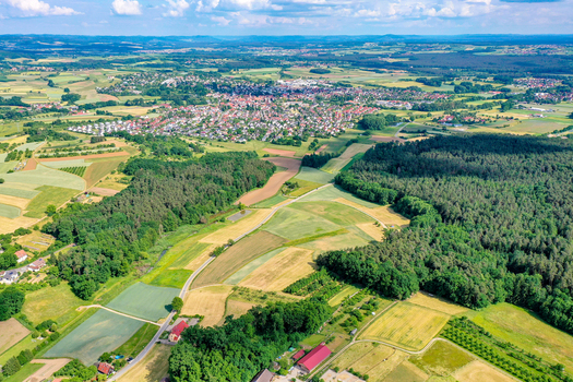 Aerial view of the town surrounded by lush green fields agricultural land and dense forests under a bright sky Neunkirchen am Brand Bavaria Germany. Aerial view of the town surrounded by lush green fields agricultural land and dense forests under a bright sky Neunkirchen am Brand Bavaria Germany.