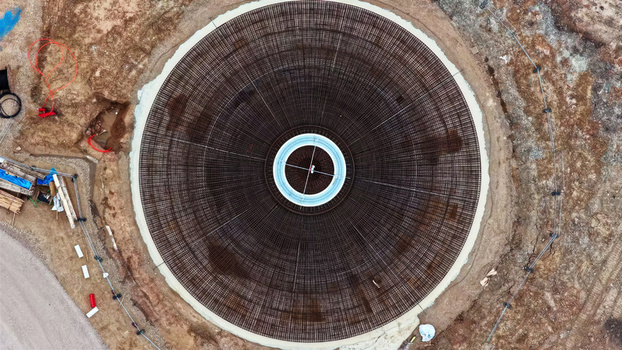 Aerial view of a circular wind turbine foundation featuring intricate steel rebar reinforcement patterns at a construction site in Latvia. Aerial view of a circular wind turbine foundation featuring intricate steel rebar reinforcement patterns at a construction site in Latvia.