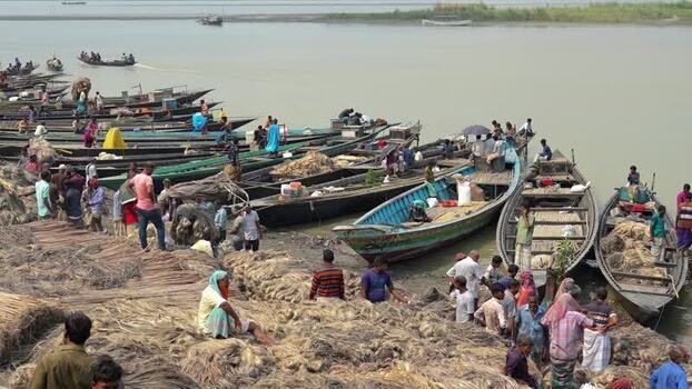 View of workers and boats on a riverbank in Jamalpur Bangladesh.