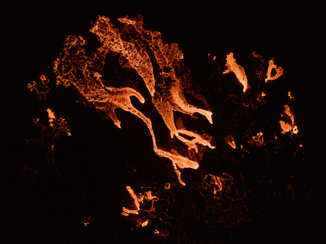 Aerial view of glowing lava flows from a volcanic eruption spreading across the dark volcanic landscape in Iceland. Aerial view of glowing lava flows from a volcanic eruption spreading across the dark volcanic landscape in Iceland.