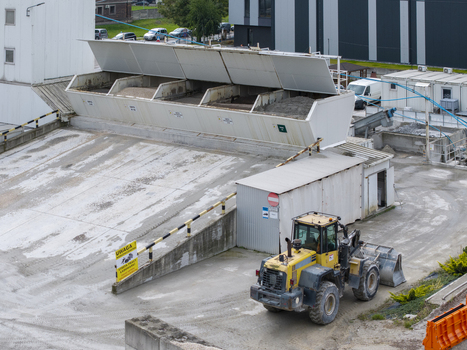 Aerial view of the Holcim concrete plant featuring aggregate storage bins and a yellow wheel loader operating on the industrial site in Krakow Lesser Poland Voivode Poland.