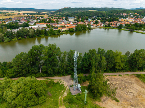 Aerial view of a telecommunications tower situated near a lake with the town of Zebrak and castle ruins in the background in Zebrak Central Bohemian Region Czechia. Aerial view of a telecommunications tower situated near a lake with the town of Zebrak and castle ruins in the background in Zebrak Central Bohemian Region Czechia.