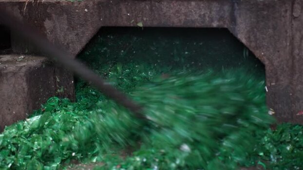 View of green glass shards being shoveled into a chute Bangladesh. View of green glass shards being shoveled into a chute Bangladesh.