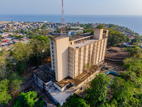 Aerial view of the abandoned Ducor Intercontinental Hotel and a radio tower overlooking the cityscape and Atlantic Ocean in Monrovia Montserrado Liberia. Aerial view of the abandoned Ducor Intercontinental Hotel and a radio tower overlooking the cityscape and Atlantic Ocean in Monrovia Montserrado Liberia.