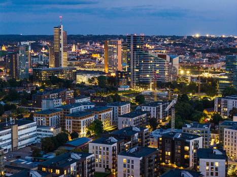 Aerial view of the modern skyline of Vilnius with illuminated skyscrapers and residential buildings at twilight in Vilnius Vilnius County Lithuania. Aerial view of the modern skyline of Vilnius with illuminated skyscrapers and residential buildings at twilight in Vilnius Vilnius County Lithuania.