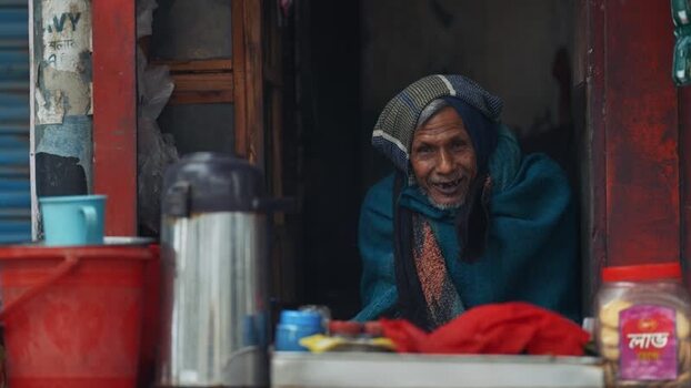 View of an elderly man smiling in a small shop in Bangladesh. View of an elderly man smiling in a small shop in Bangladesh.