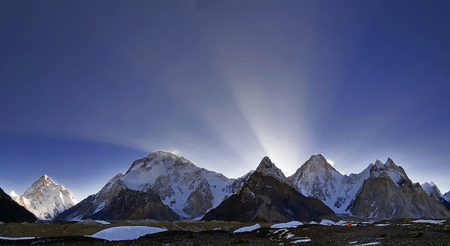 View of Karakoram peaks including K2 Broad Peak Gasherbrum IV and Gasherbrum I from the Concordia Campsite with snow capped summits and sun rays in Skardu Gilgit Baltistan Pakistan.