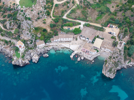 Aerial view of the Riserva Naturale Orientata dello Zingaro featuring historic stone buildings rugged coastal cliffs and turquoise sea waters in San Vito Lo Capo Sicilia Italy. Aerial view of the Riserva Naturale Orientata dello Zingaro featuring historic stone buildings rugged coastal cliffs and turquoise sea waters in San Vito Lo Capo Sicilia Italy.