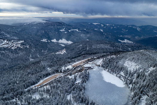 Aerial view of the frozen Mummelsee surrounded by snow covered pine forests and mountains in the Black Forest in Seebach Baden Wurttemberg Germany. Aerial view of the frozen Mummelsee surrounded by snow covered pine forests and mountains in the Black Forest in Seebach Baden Wurttemberg Germany.