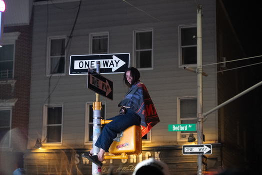 Williamsburg New York USA 14 June 2026 View of a fan celebrating the Knicks NBA championship victory by sitting on a street sign pole at night on Bedford Avenue. Williamsburg New York USA 14 June 2026 View of a fan celebrating the Knicks NBA championship victory by sitting on a street sign pole at night on Bedford Avenue.