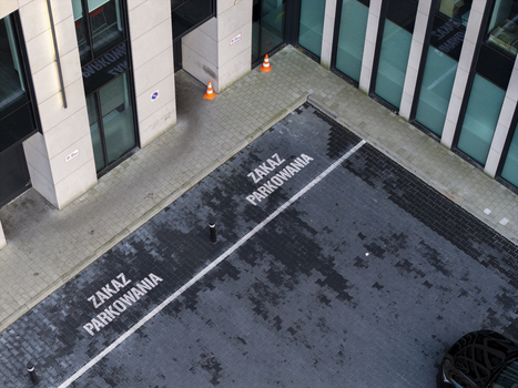 Aerial view of a parking area with no parking signs painted on the pavement next to a modern office building in Krakow Lesser Poland Voivode Poland.