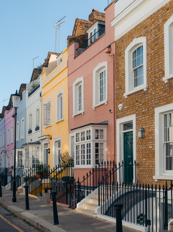 London United Kingdom 21 June 2025 View of a row of houses painted in pastel shades their vibrant facades creating a cheerful streetscape. London United Kingdom 21 June 2025 View of a row of houses painted in pastel shades their vibrant facades creating a cheerful streetscape.