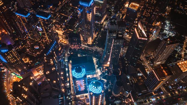 Aerial view of illuminated skyscrapers and city streets at night in Jakarta Indonesia.