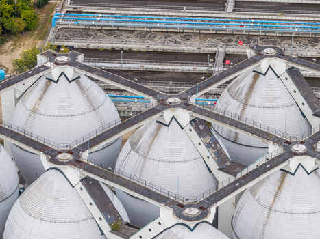 Aerial view of the Klarwerk Ruhleben sewage treatment plant with its distinctive white digester tanks and connecting walkways in Berlin Berlin Germany.