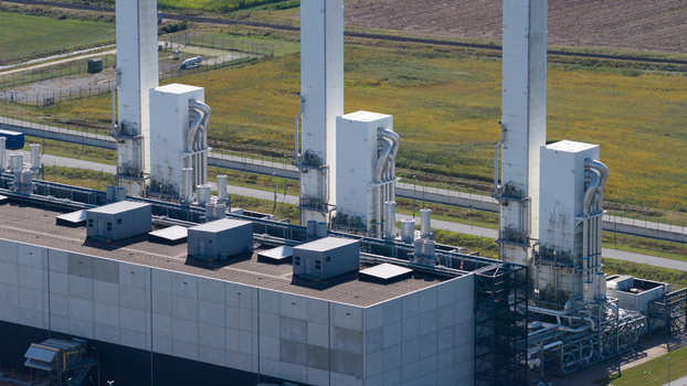 Aerial view of the Gasunie and Air Products nitrogen factory featuring tall white industrial towers and complex piping systems in the rural landscape of Muntendam Groningen Netherlands.