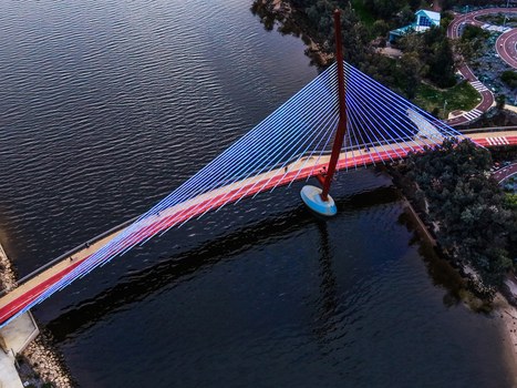 Aerial view of Boorloo Bridge spanning the Swan River with its striking red pylon and blue cables set against the parkland of East Perth Western Australia Australia.