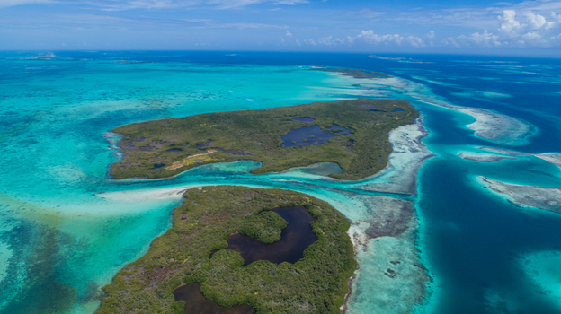 Aerial view of Los Roques archipelago featuring turquoise Caribbean waters coral reefs and lush green islands under a clear blue sky. Los Roques Dependencias Federale Venezuela. Aerial view of Los Roques archipelago featuring turquoise Caribbean waters coral reefs and lush green islands under a clear blue sky. Los Roques Dependencias Federale Venezuela.