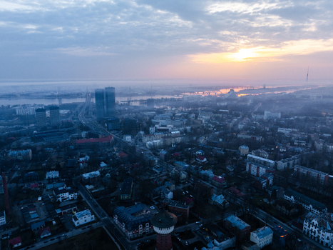 Aerial view of the cityscape of Riga at sunset featuring the Agenskalna area with its characteristic pine trees historic buildings and the Daugava River in the distance Riga Latvia. Aerial view of the cityscape of Riga at sunset featuring the Agenskalna area with its characteristic pine trees historic buildings and the Daugava River in the distance Riga Latvia.