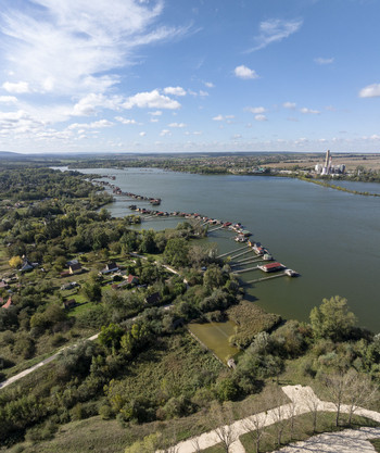 Aerial view of Bokodi Floating Village with its iconic wooden houses on stilts over the lake surrounded by lush greenery and calm water in Oroszlany Hungary. Aerial view of Bokodi Floating Village with its iconic wooden houses on stilts over the lake surrounded by lush greenery and calm water in Oroszlany Hungary.