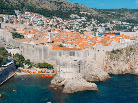 View of Dubrovnik Old Town with its historic stone walls orange rooftops and kayaks on the turquoise sea Dubrovnik Dubrovnik Neretva County Croatia. View of Dubrovnik Old Town with its historic stone walls orange rooftops and kayaks on the turquoise sea Dubrovnik Dubrovnik Neretva County Croatia.