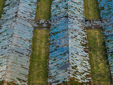 Aerial view of abandoned greenhouses with broken glass panels and overgrown green grass in Vilnius County Lithuania. Aerial view of abandoned greenhouses with broken glass panels and overgrown green grass in Vilnius County Lithuania.