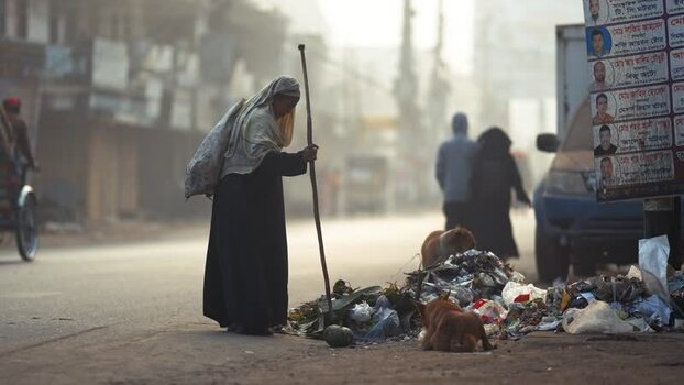 View of Bogura with a woman standing by trash on a street Bangladesh. View of Bogura with a woman standing by trash on a street Bangladesh.