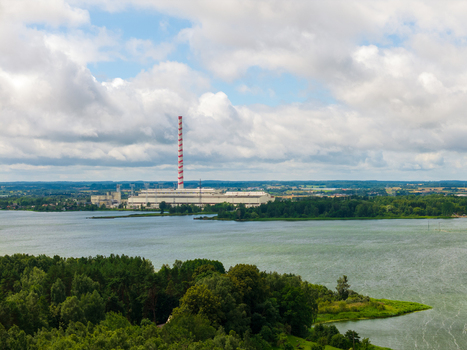 Aerial view of the Elektrenai Power Plant with its red and white striped chimney situated by a lake and forests under a cloudy sky in Elektrenai Vilnius County Lithuania. Aerial view of the Elektrenai Power Plant with its red and white striped chimney situated by a lake and forests under a cloudy sky in Elektrenai Vilnius County Lithuania.