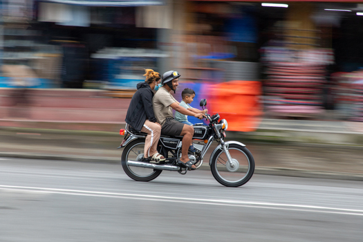Pokhara Nepal 31 July 2026 View of a family of three riding a motorcycle along a city street with a motion blur background.