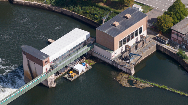 Aerial view of the Neckar Staustufe und Schleuse Rockenau featuring the lock and weir infrastructure on the Neckar river with a maintenance barge in Eberbach Baden Wurttemberg Germany. Aerial view of the Neckar Staustufe und Schleuse Rockenau featuring the lock and weir infrastructure on the Neckar river with a maintenance barge in Eberbach Baden Wurttemberg Germany.