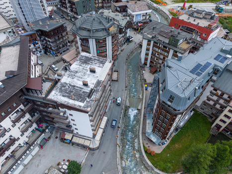 Aerial view of the mountain village of Breuil Cervinia with alpine architecture hotels and a stream flowing through the center in Breuil Cervinia Aosta Valley Italy. Aerial view of the mountain village of Breuil Cervinia with alpine architecture hotels and a stream flowing through the center in Breuil Cervinia Aosta Valley Italy.