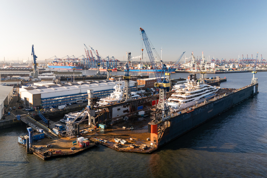 Aerial view of the Port of Hamburg featuring luxury yachts in dry dock with industrial cranes and harbor infrastructure in Hamburg Hamburg Germany.