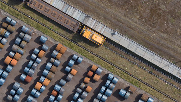 Aerial view of the Tata Steel industrial site with a yellow locomotive on tracks and rows of metal coils in Velsen Noord Noord Holland Netherlands. Aerial view of the Tata Steel industrial site with a yellow locomotive on tracks and rows of metal coils in Velsen Noord Noord Holland Netherlands.