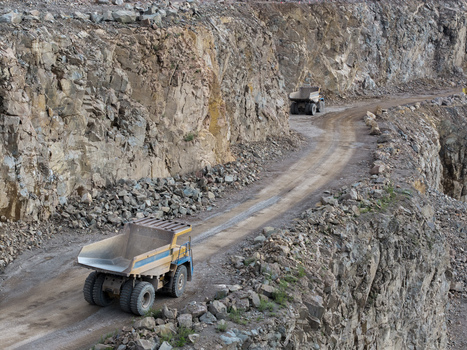 Aerial view of the kopalnia porfiru i diabazu quarry featuring large mining dump trucks on a dirt path between steep rock walls in Krakow Lesser Poland Voivode Poland. Aerial view of the kopalnia porfiru i diabazu quarry featuring large mining dump trucks on a dirt path between steep rock walls in Krakow Lesser Poland Voivode Poland.