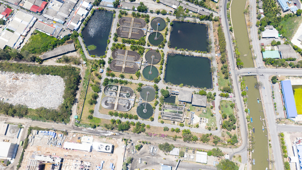 Aerial view of a wastewater treatment plant featuring circular sedimentation tanks and aeration basins surrounded by lush greenery in Phuket Phuket Thailand. Aerial view of a wastewater treatment plant featuring circular sedimentation tanks and aeration basins surrounded by lush greenery in Phuket Phuket Thailand.
