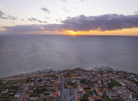 Aerial view of the coastal village of Audresselles with its charming rooftops and houses along the shoreline during a vibrant sunset in Audresselles Hauts de France France.