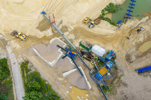 Aerial view of a sand and gravel mine with heavy machinery conveyor belts and piles of sand in Masovian Voivodeship Poland.
