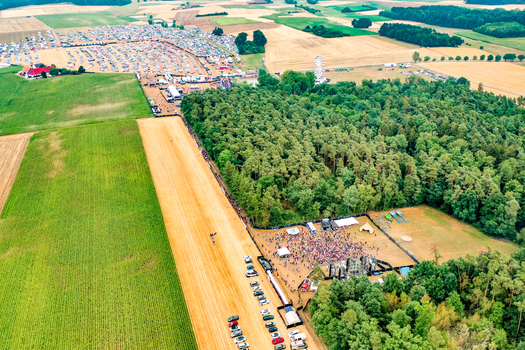 Herzogenaurach Germany 22 July 2022 Aerial view of the Open Beatz Festival featuring stages crowds of people and a ferris wheel surrounded by lush green fields and forests. Herzogenaurach Germany 22 July 2022 Aerial view of the Open Beatz Festival featuring stages crowds of people and a ferris wheel surrounded by lush green fields and forests.
