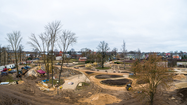 Aerial view of a park under construction with wooden playground structures winding paths and landscaping work in progress in Latvia. Aerial view of a park under construction with wooden playground structures winding paths and landscaping work in progress in Latvia.